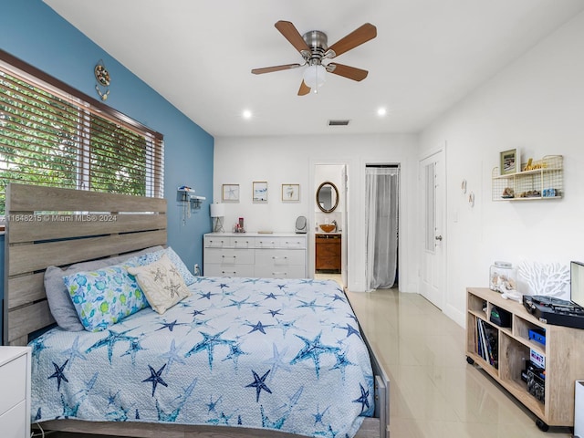 bedroom with ceiling fan, ensuite bath, and light tile patterned flooring