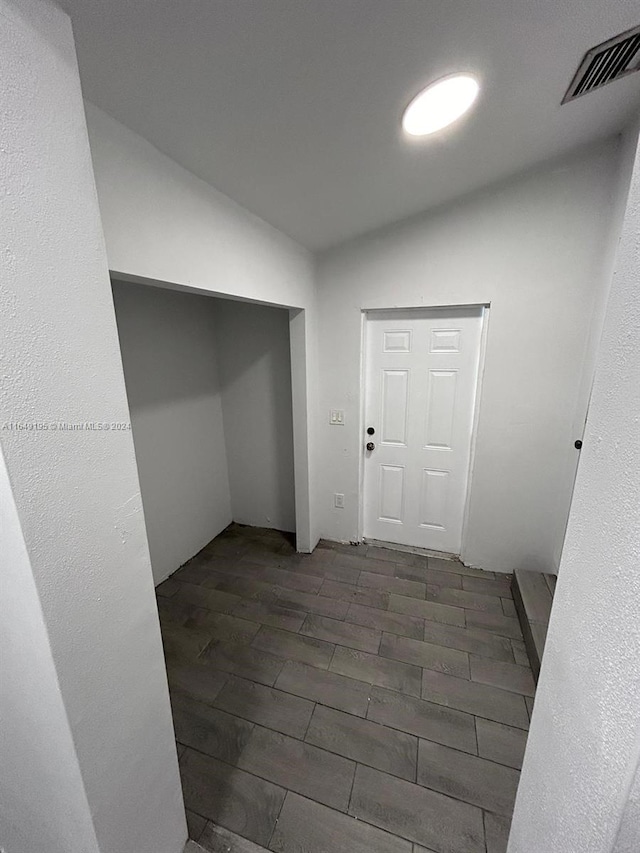 hallway with lofted ceiling and dark hardwood / wood-style floors