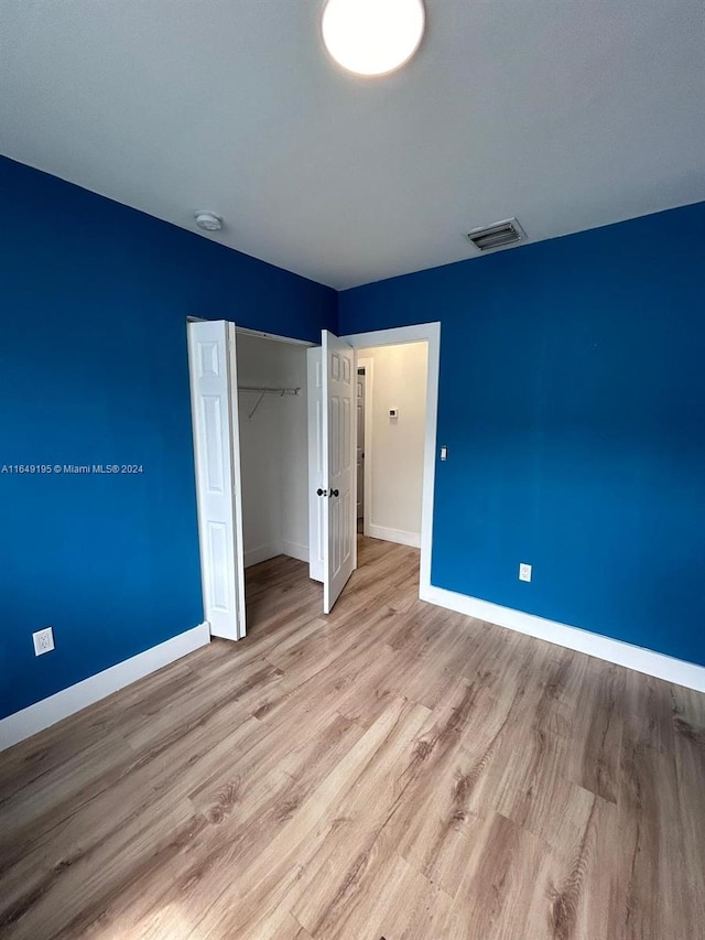 unfurnished bedroom featuring a closet and light hardwood / wood-style floors