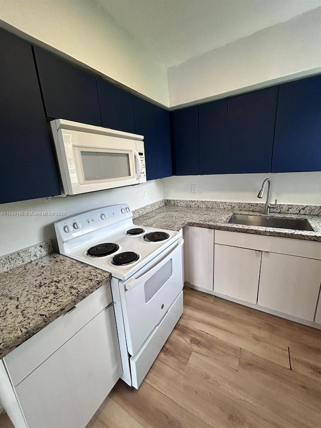 kitchen featuring light wood-type flooring, white appliances, white cabinetry, and sink