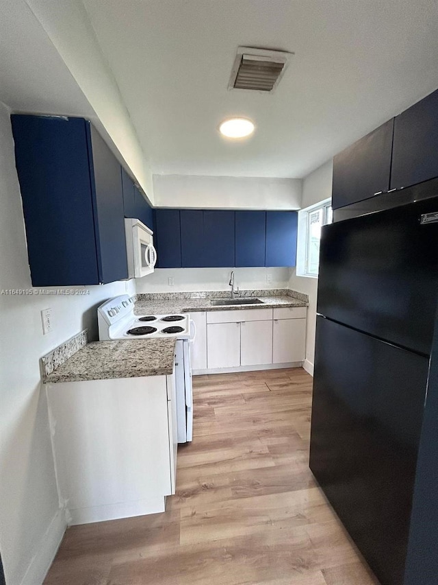 kitchen featuring blue cabinetry, white appliances, light hardwood / wood-style floors, and sink