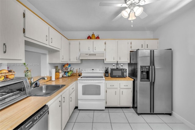 kitchen featuring appliances with stainless steel finishes, sink, white cabinetry, ceiling fan, and light tile patterned flooring