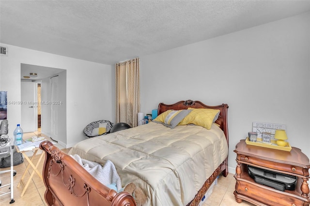 bedroom with a textured ceiling and light tile patterned floors