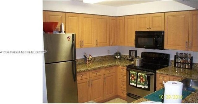 kitchen with stainless steel appliances and dark stone counters