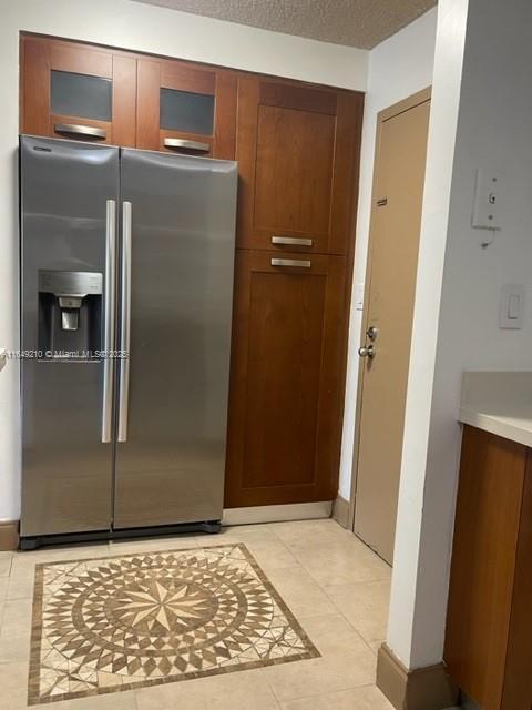 kitchen featuring light tile patterned floors and stainless steel fridge