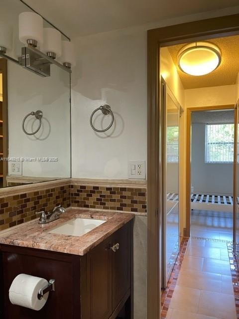 bathroom featuring tasteful backsplash, vanity, and tile patterned flooring