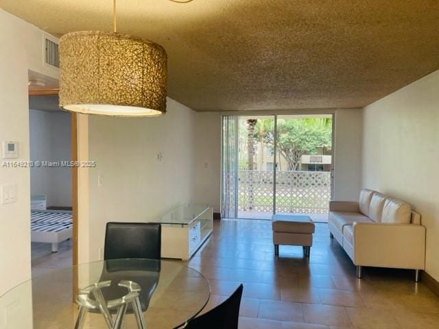 living room featuring floor to ceiling windows and a textured ceiling