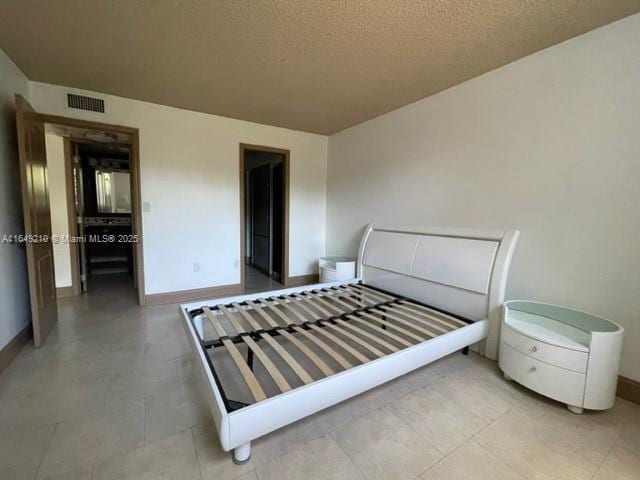 tiled bedroom with a textured ceiling