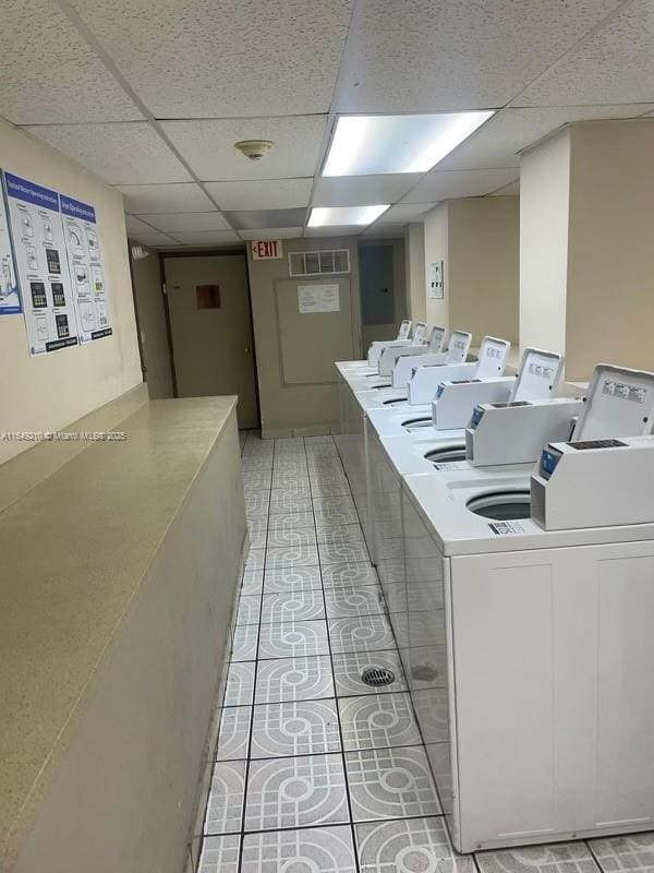 laundry area with washer and clothes dryer and light tile patterned floors