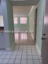 hall featuring light tile patterned flooring