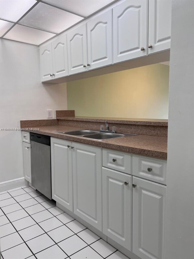 kitchen featuring white cabinets, light tile patterned flooring, stainless steel dishwasher, and sink