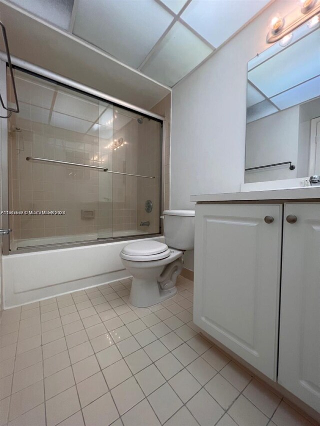 full bathroom with vanity, toilet, tile patterned floors, and bath / shower combo with glass door