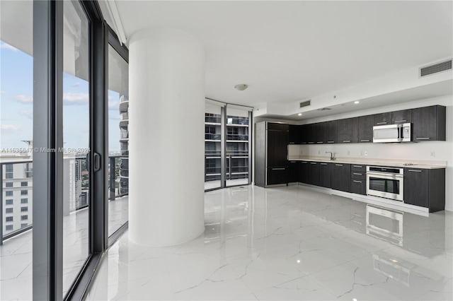 unfurnished living room featuring a wealth of natural light, floor to ceiling windows, and light tile patterned flooring