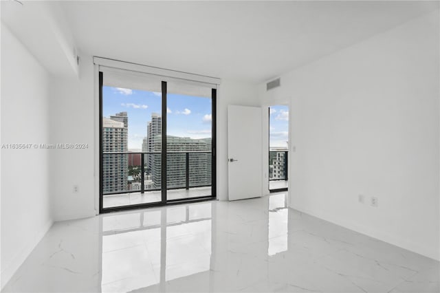 unfurnished room with expansive windows and light tile patterned floors