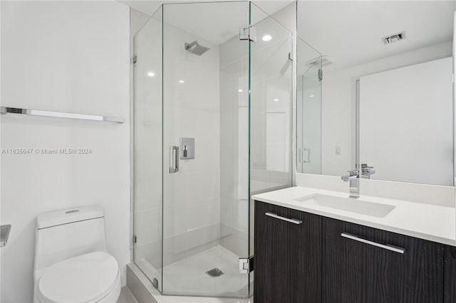 bathroom featuring vanity, toilet, and an enclosed shower