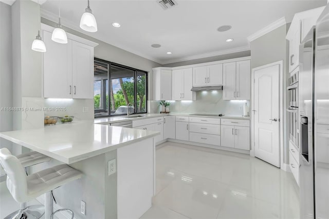 kitchen featuring white cabinetry, sink, kitchen peninsula, pendant lighting, and a breakfast bar area