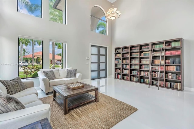 living room featuring a towering ceiling and a notable chandelier