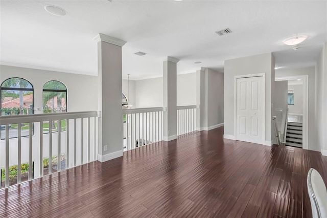 empty room with hardwood / wood-style flooring and ornamental molding