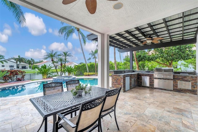 view of patio / terrace featuring a swimming pool with hot tub, an outdoor kitchen, and area for grilling