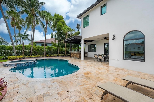 view of swimming pool with ceiling fan, a patio area, and an in ground hot tub