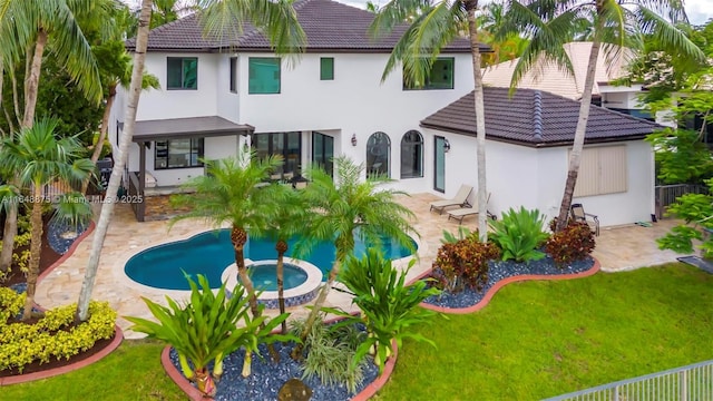 rear view of property with a yard, a fenced in pool, and a patio area