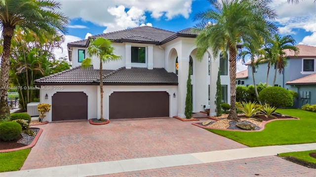 mediterranean / spanish house featuring a garage and a front lawn