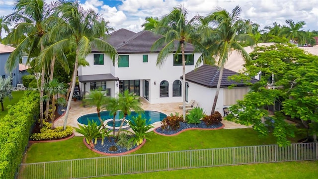 rear view of property with a yard, a fenced in pool, and a patio area