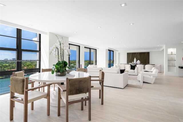 dining room with a wall of windows, light tile patterned flooring, built in shelves, and french doors