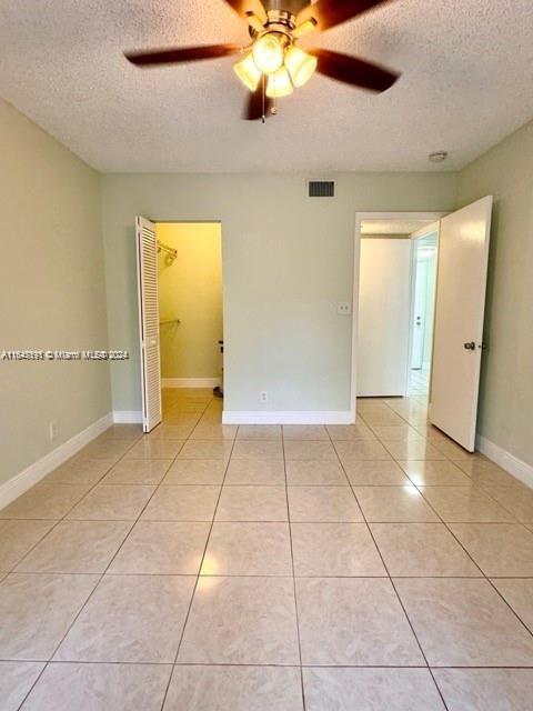 interior space with a textured ceiling and ceiling fan