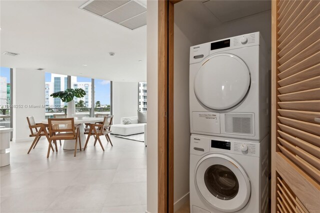 clothes washing area featuring stacked washer and clothes dryer