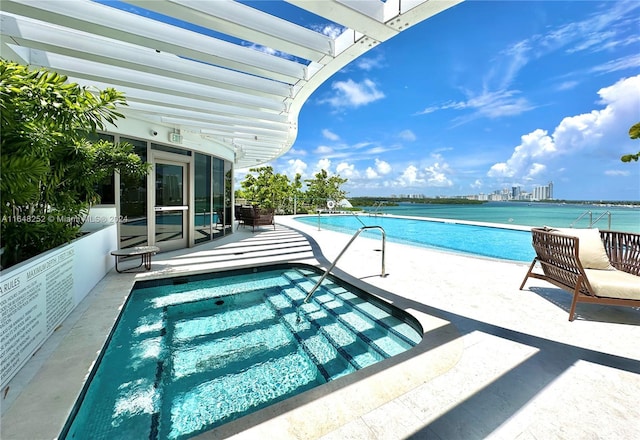 view of swimming pool featuring a patio area and a water view