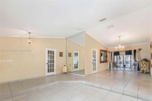 tiled empty room featuring a notable chandelier, lofted ceiling, ornamental molding, and french doors