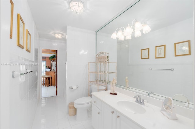 bathroom featuring tile patterned flooring, vanity, toilet, and tile walls