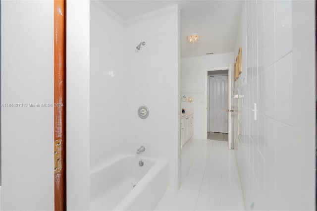 bathroom with vanity, tiled shower / bath, tile patterned flooring, ornamental molding, and tile walls