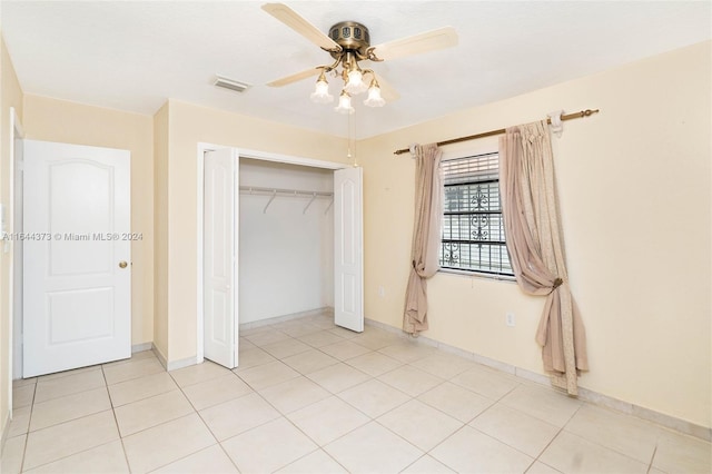 unfurnished bedroom with ceiling fan, light tile patterned flooring, and a closet