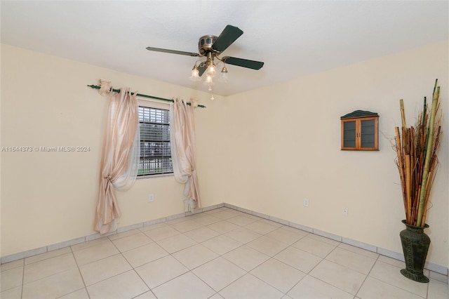 tiled empty room featuring ceiling fan