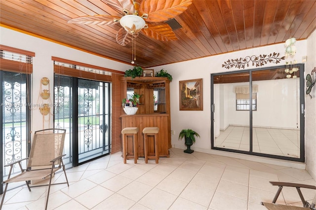 tiled dining space featuring ceiling fan, wooden ceiling, and crown molding