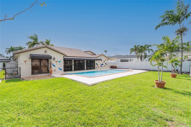 back of house with a yard, a fenced in pool, and a patio area