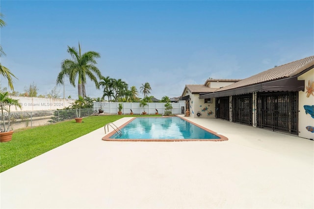 view of swimming pool featuring a yard and a patio area