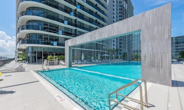 view of swimming pool featuring pool water feature and a patio area