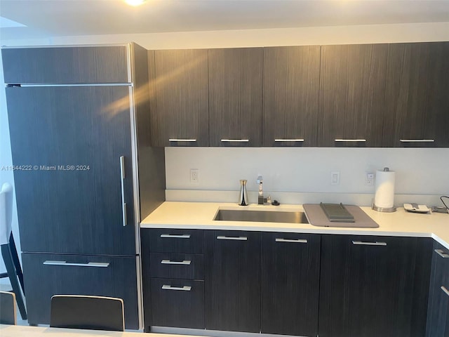 kitchen featuring built in fridge and sink