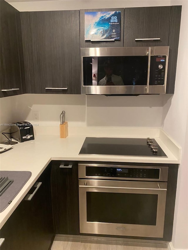 kitchen featuring stainless steel appliances and dark brown cabinets