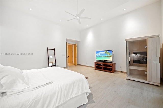 bedroom featuring light wood-type flooring, ceiling fan, and high vaulted ceiling