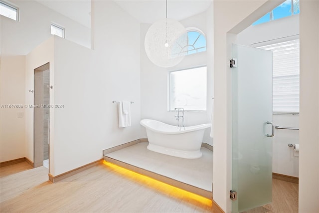 bathroom with hardwood / wood-style flooring and shower with separate bathtub