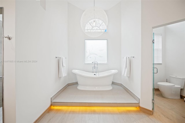 bathroom featuring independent shower and bath, toilet, and hardwood / wood-style flooring