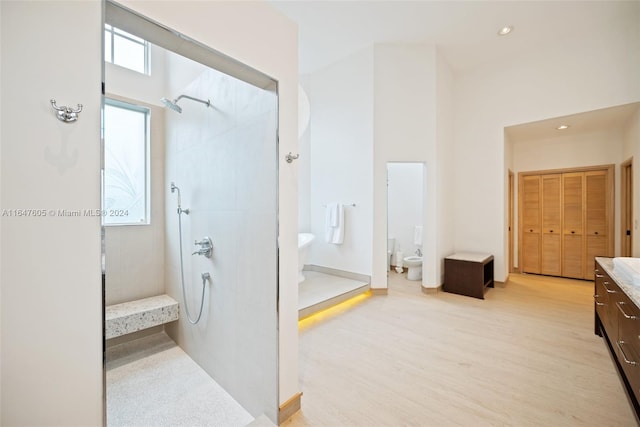 bathroom featuring a bidet, vanity, toilet, and tiled shower