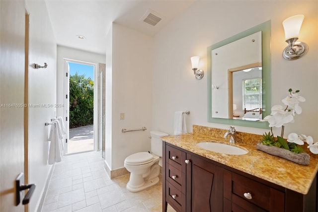 bathroom featuring plenty of natural light, toilet, vanity, and tile patterned floors