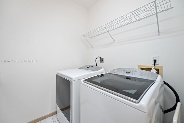 laundry room with separate washer and dryer and light tile patterned floors