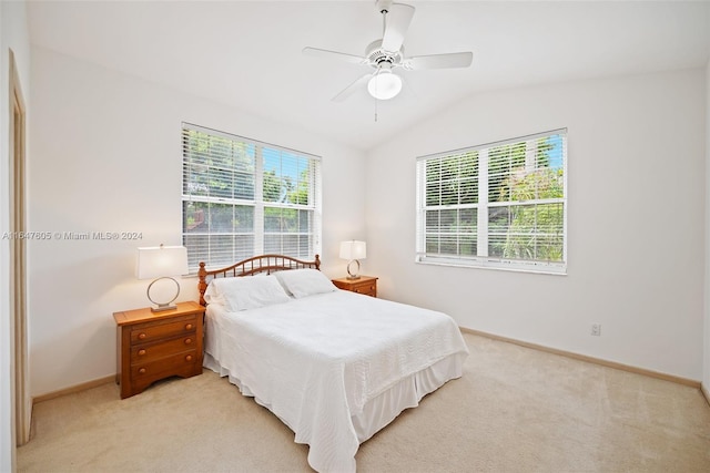 bedroom featuring vaulted ceiling, light carpet, ceiling fan, and multiple windows