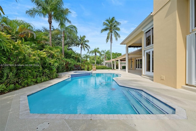 view of pool featuring an in ground hot tub and a patio